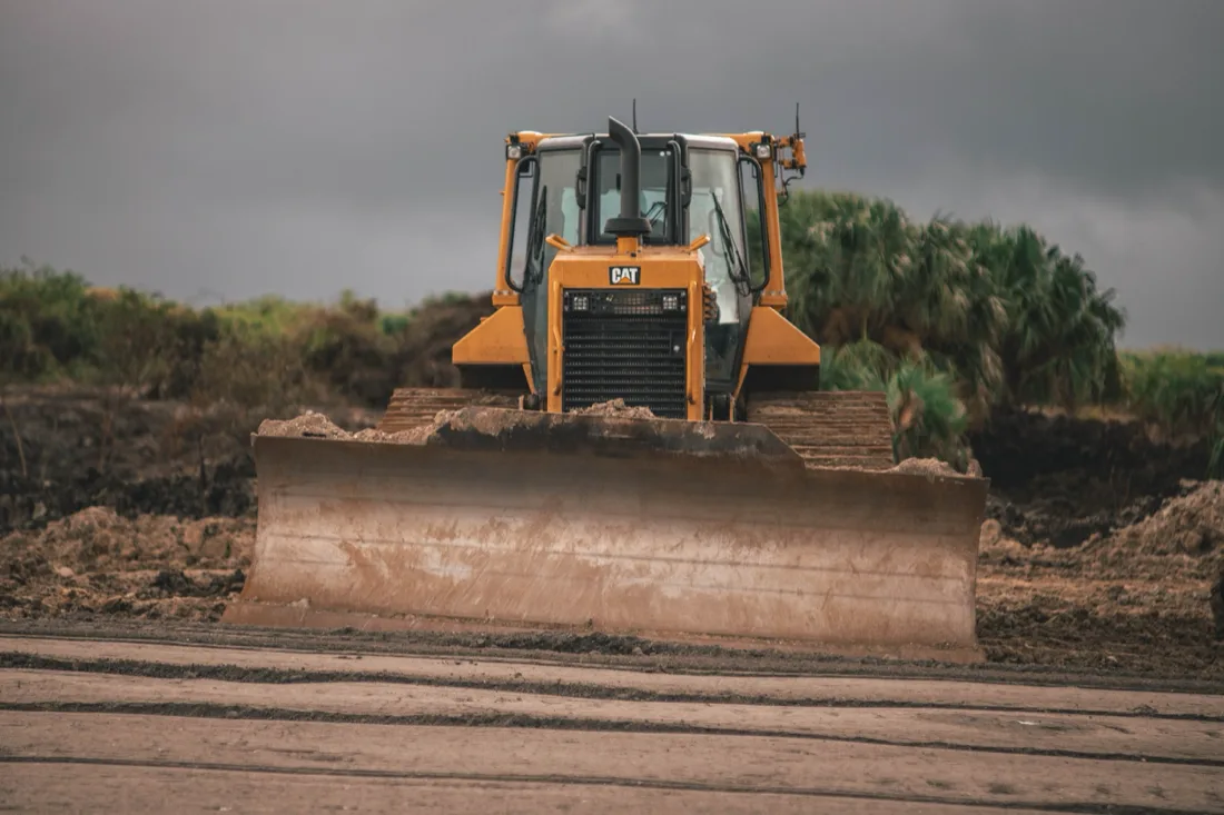 Graded and leveled dirt building pad on a cleared lot ready for a foundation